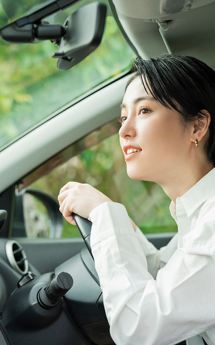 自然豊かな場所で車を運転している女性の写真